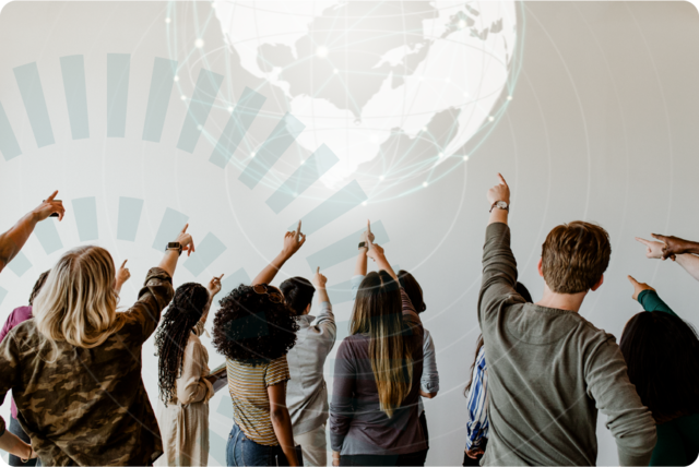 a group of people pointing towards a visualisation of the globe